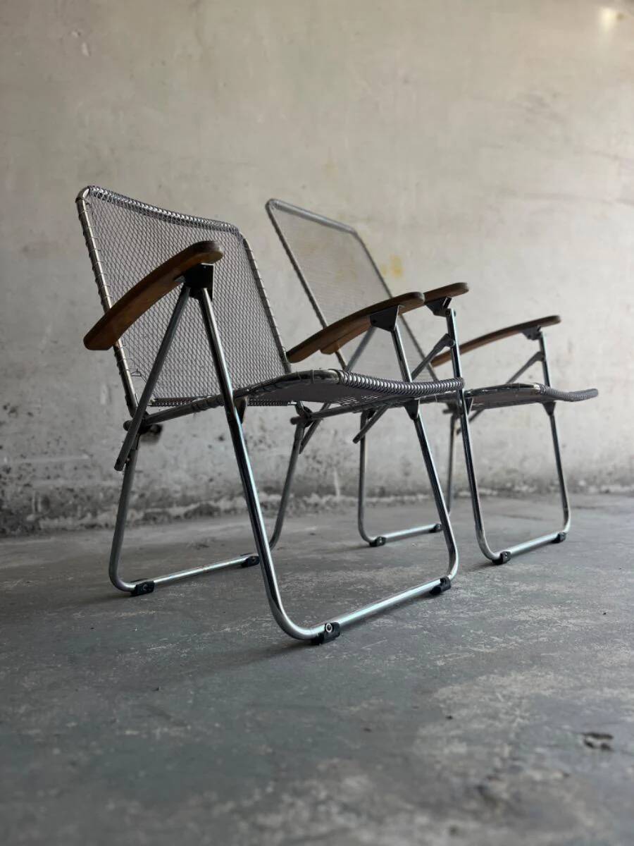 Pair of vintage silver aluminum wire folding chairs with wooden armrests — industrial minimalist