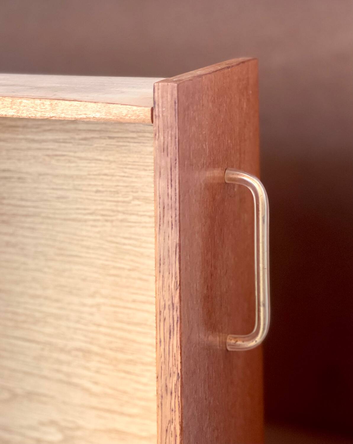 Vintage 1960s chest of drawers with covered handles.