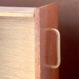 Vintage 1960s chest of drawers with covered handles.