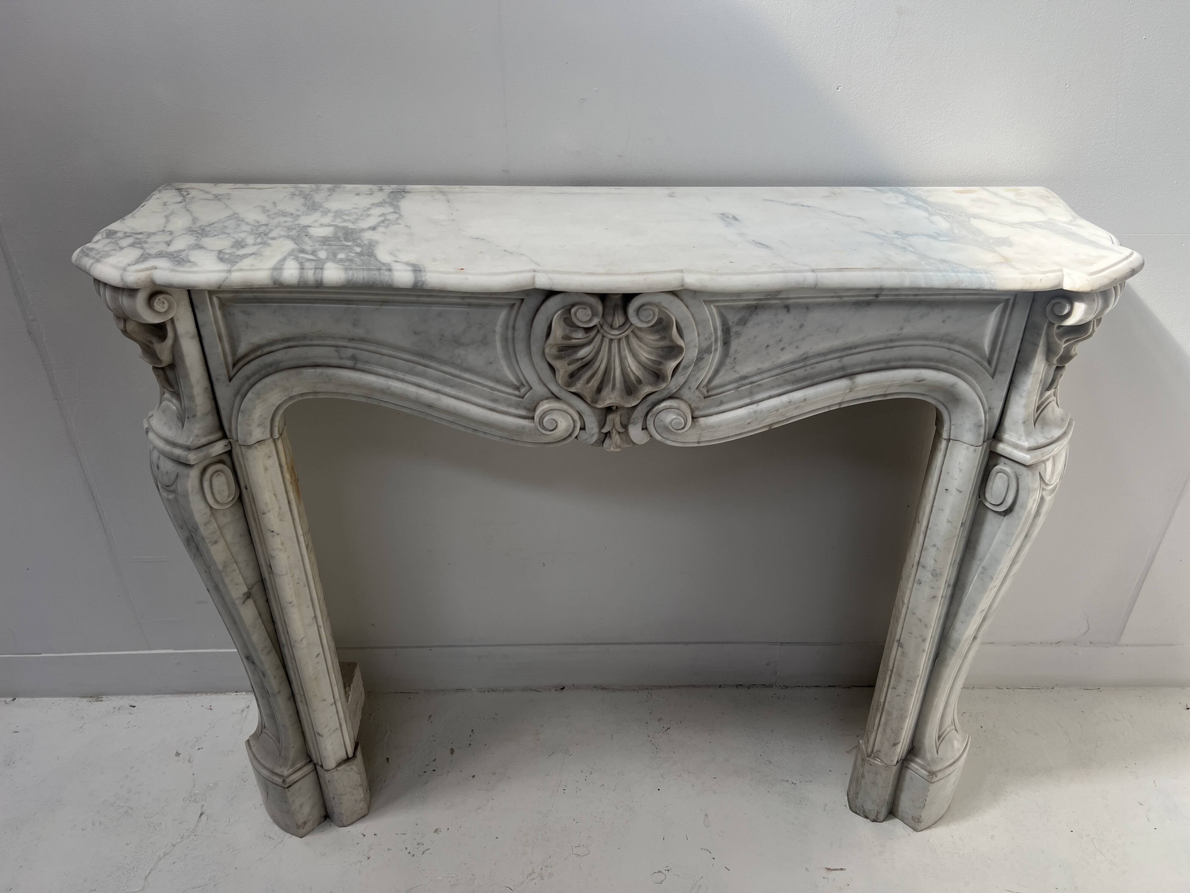 Louis XV style fireplace in veined white Carrara marble, 19th century.