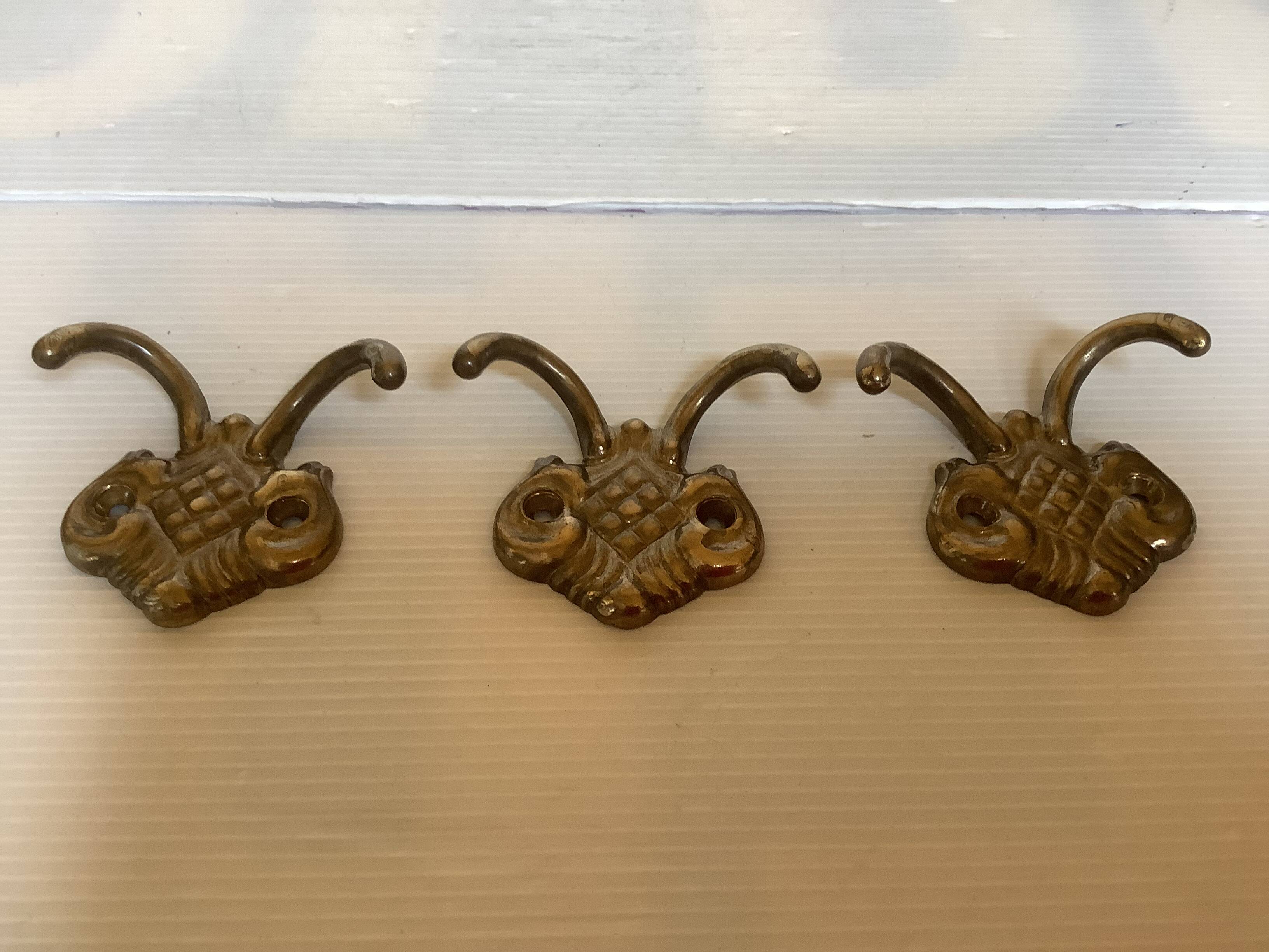 Three double brass coat hooks.