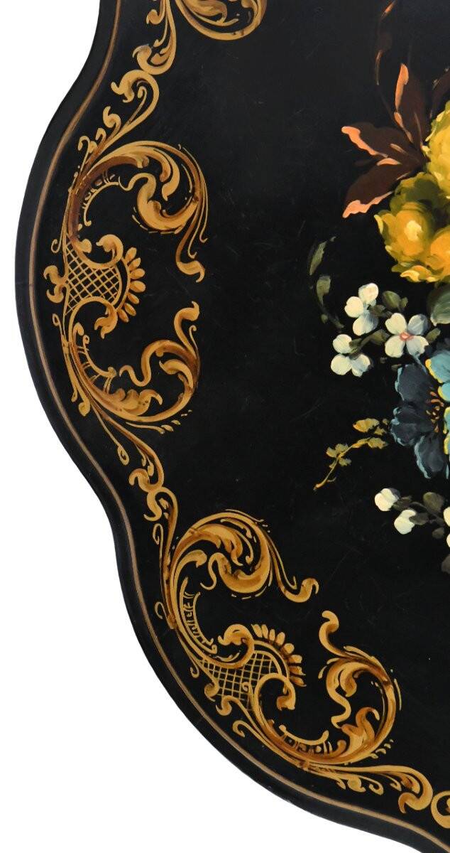 Blackened wooden side table decorated with a painted bouquet of flowers.