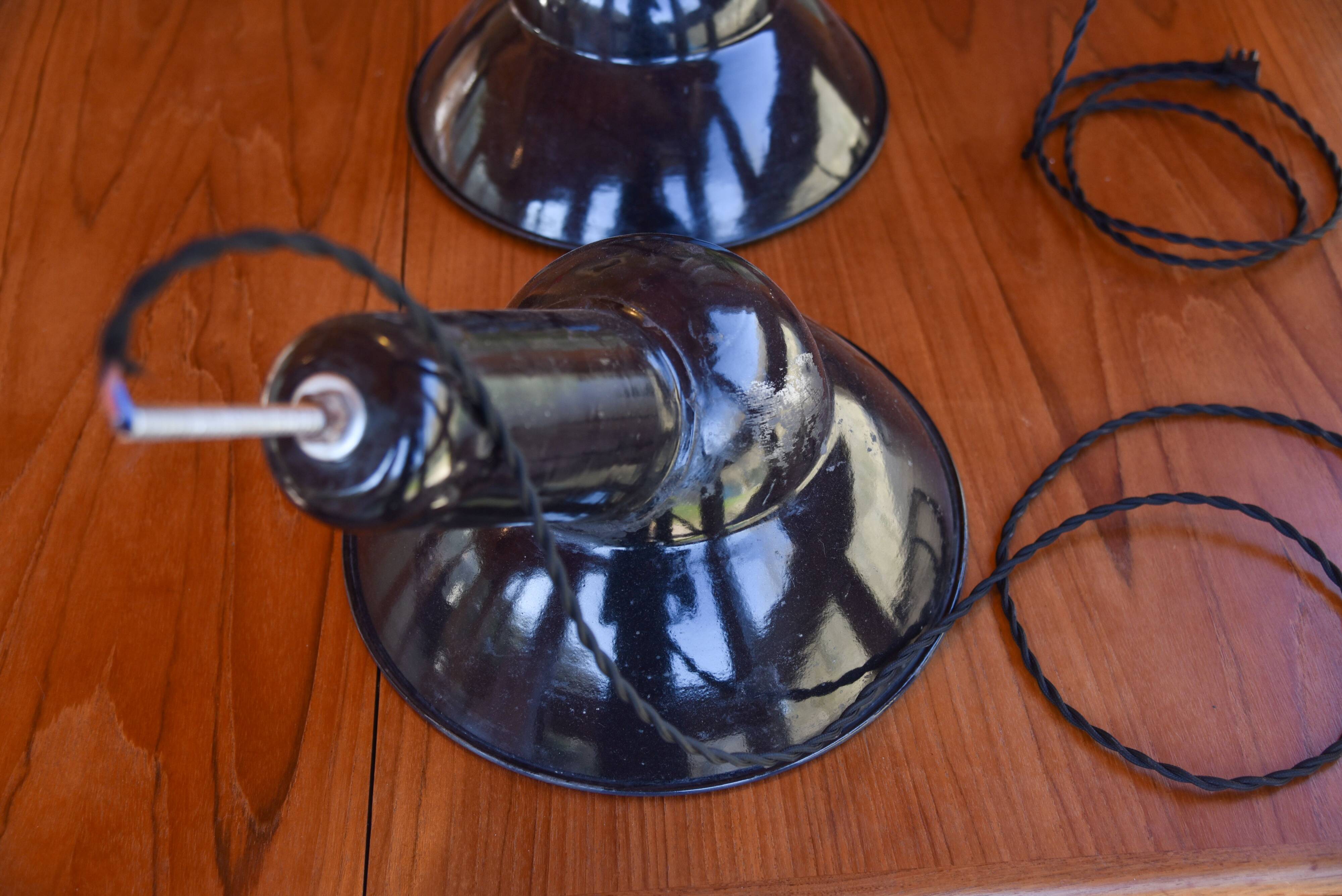 Pair of black enamelled sheet metal pendant lights from the 1950s.