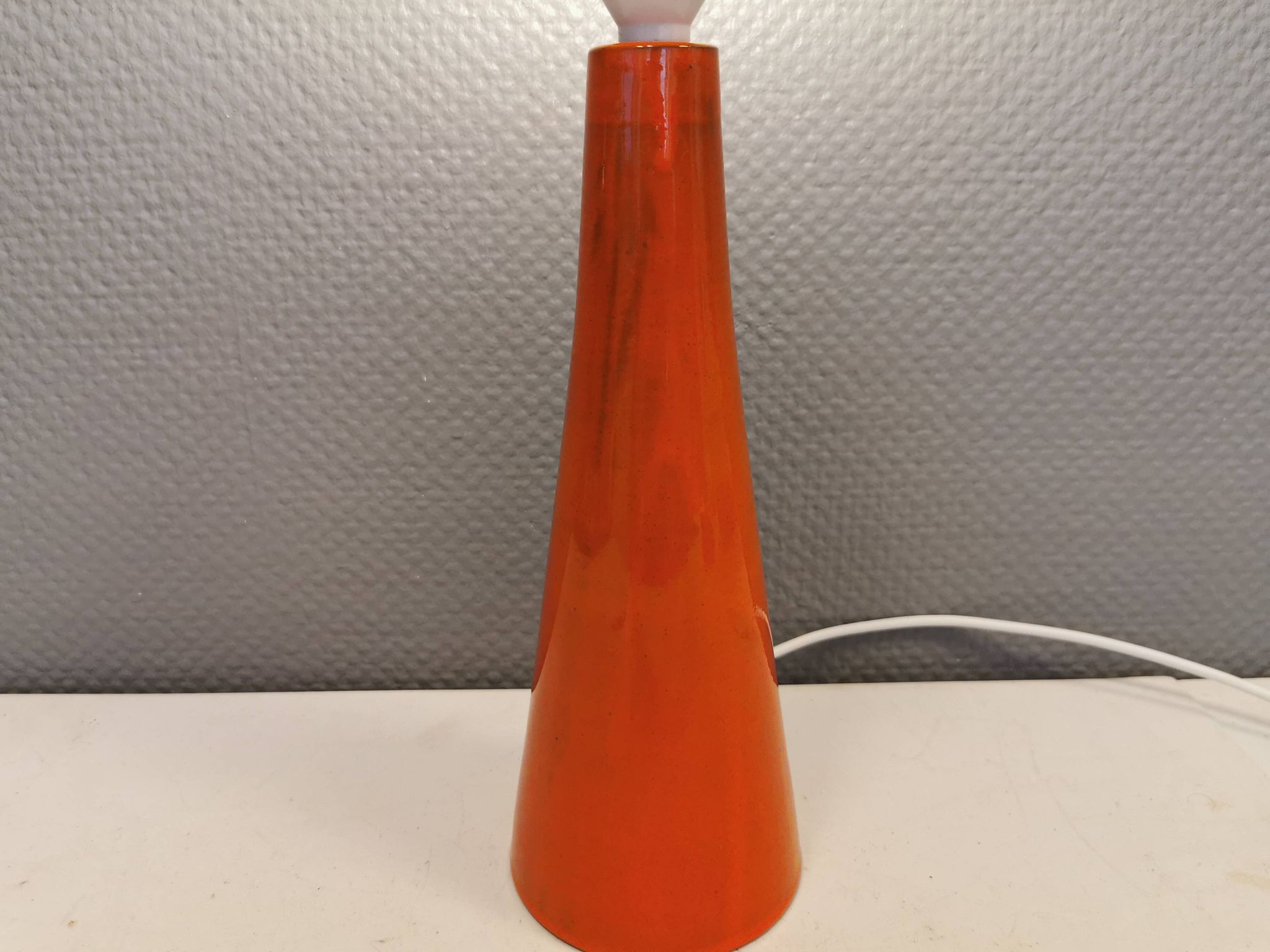 Ceramic table lamp with partial orange glaze.