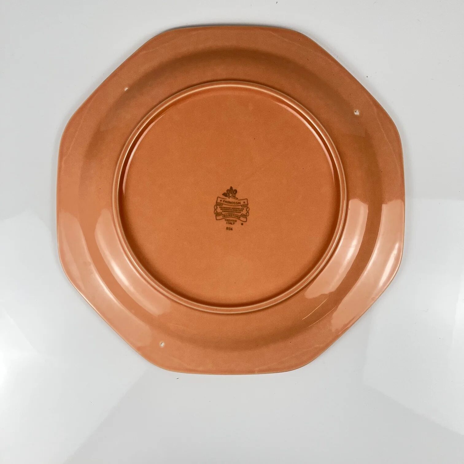 Octagonal plate in salmon pink, iron earth, Pagnossin, Italy, 20th century.