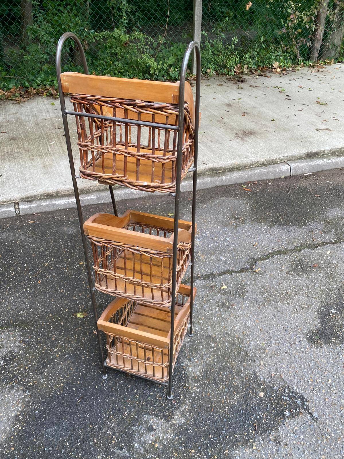 Woven rattan and steel display shelf in the shape of a staircase.