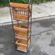 Woven rattan and steel display shelf in the shape of a staircase.