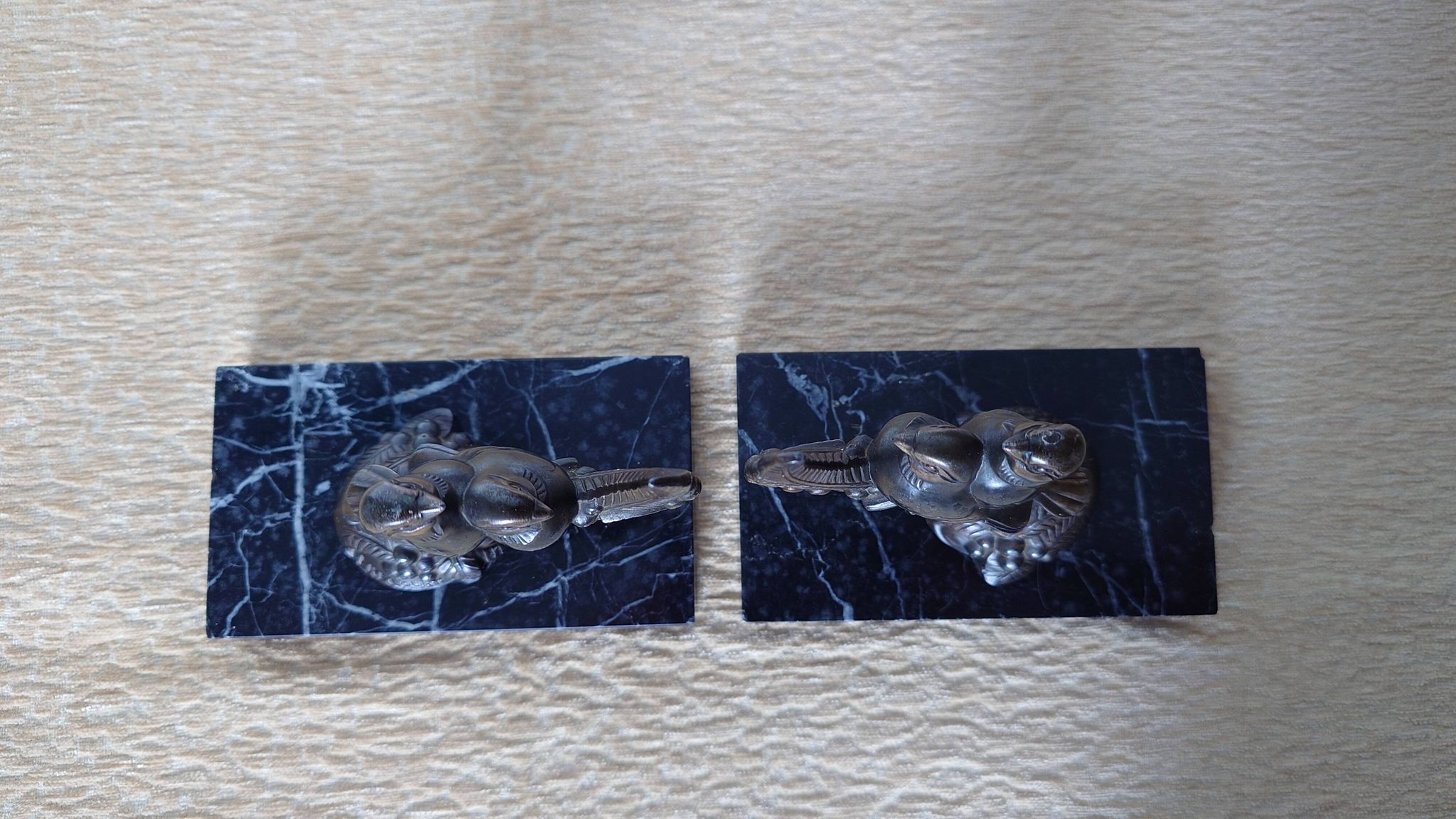 Pair of Art Deco bookends signed Frécourt, patinated metal & black marble