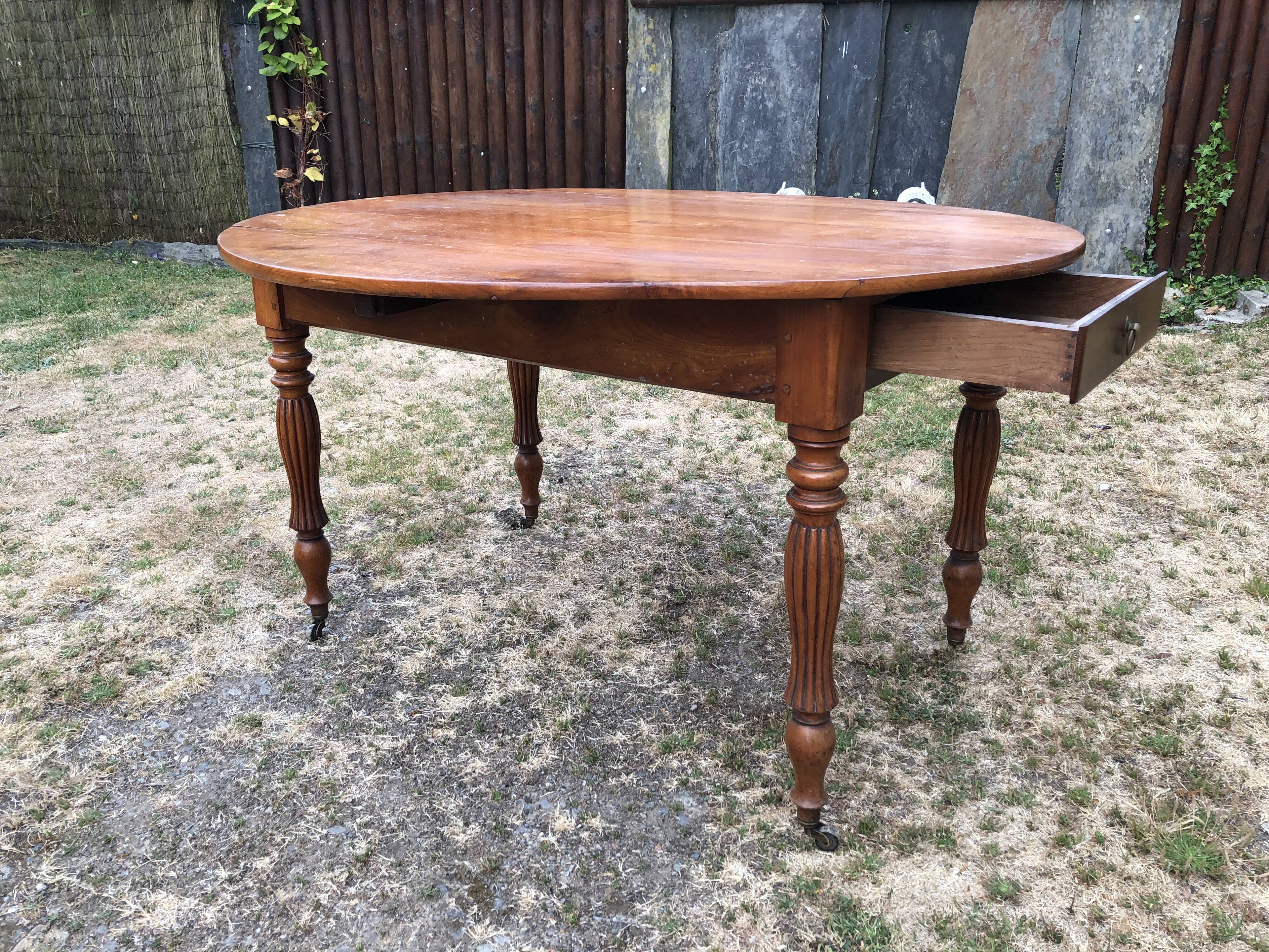 Louis Philippe oval drop-leaf table in solid cherry wood with 2 drawers.