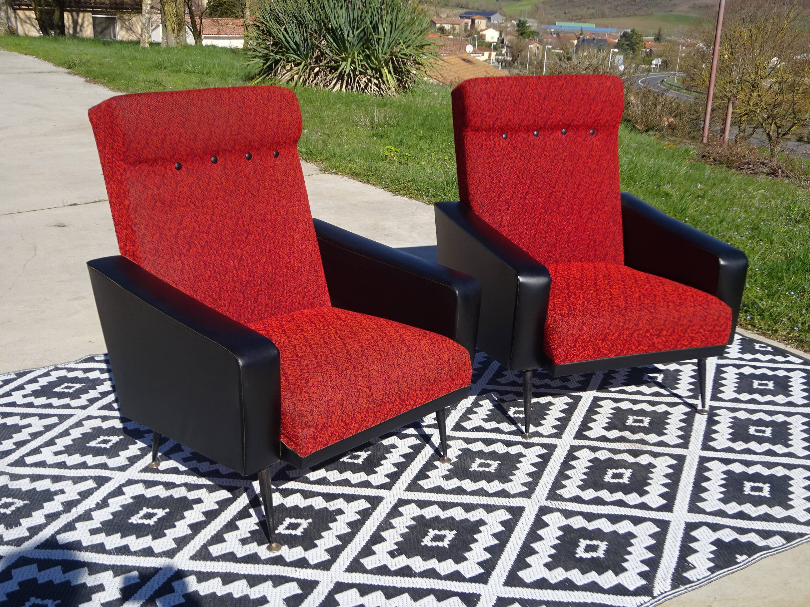 Vintage armchairs in red and black faux leather, the pair.