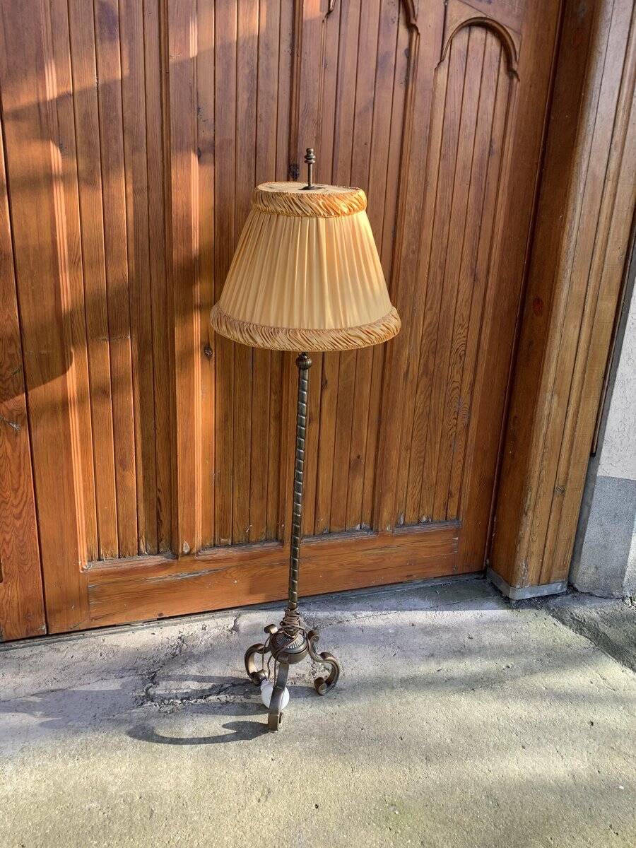 Art Deco floor lamp in bronze metal with a straw yellow fabric shade, twisted shaft, and tripod base.