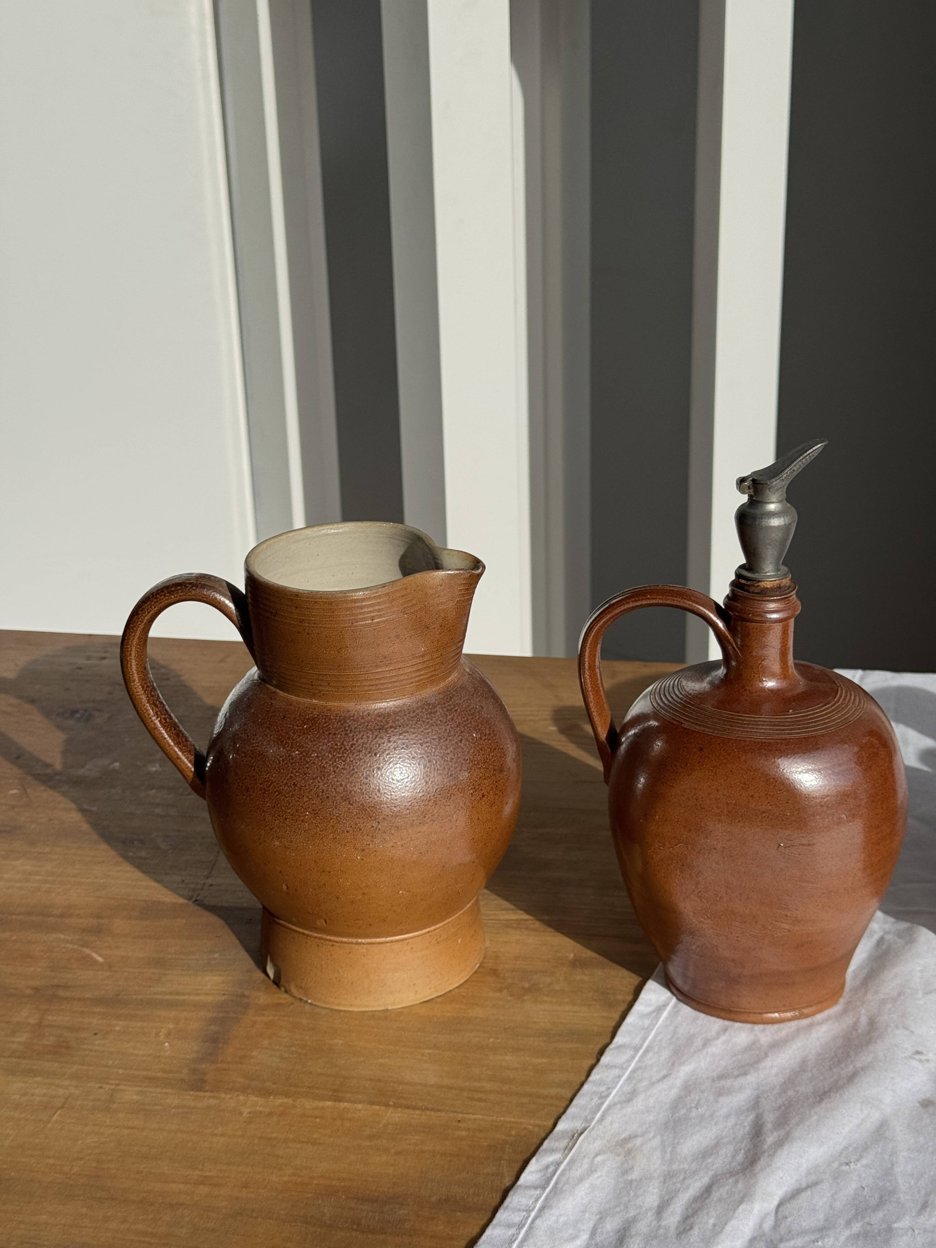 Ancient stoneware jug with a pewter spout.