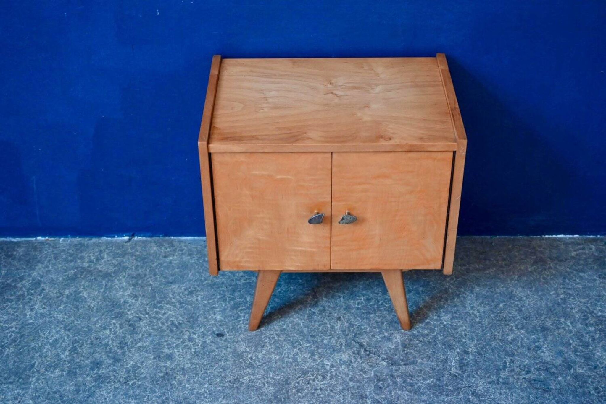 Rockabilly design bedside table with tapered legs.
