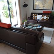 Two brown leather Crozatier two-and-a-half-seater sofas.