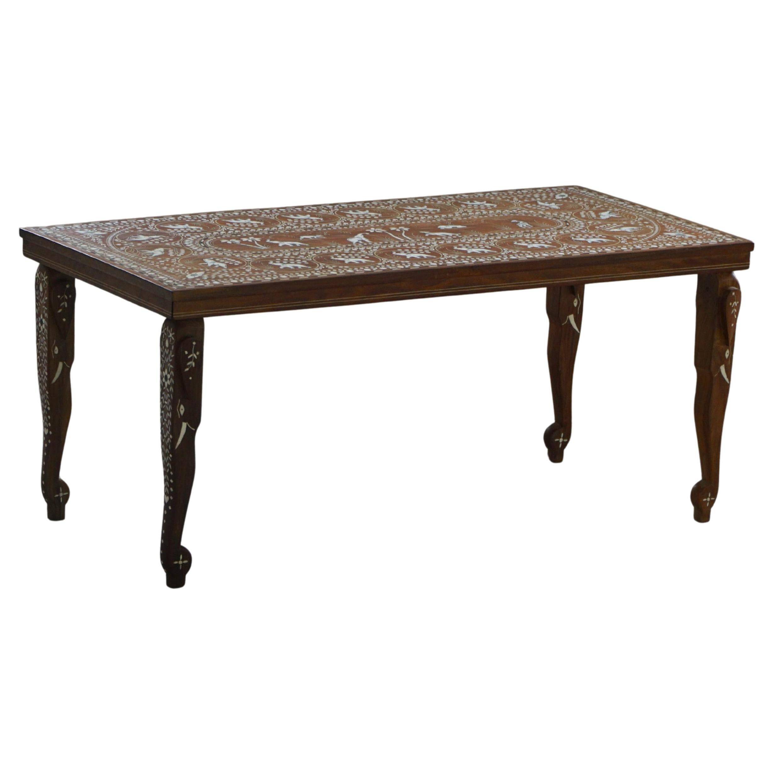 Vintage Indian teak coffee table inlaid with elephant motifs, mid-20th century.