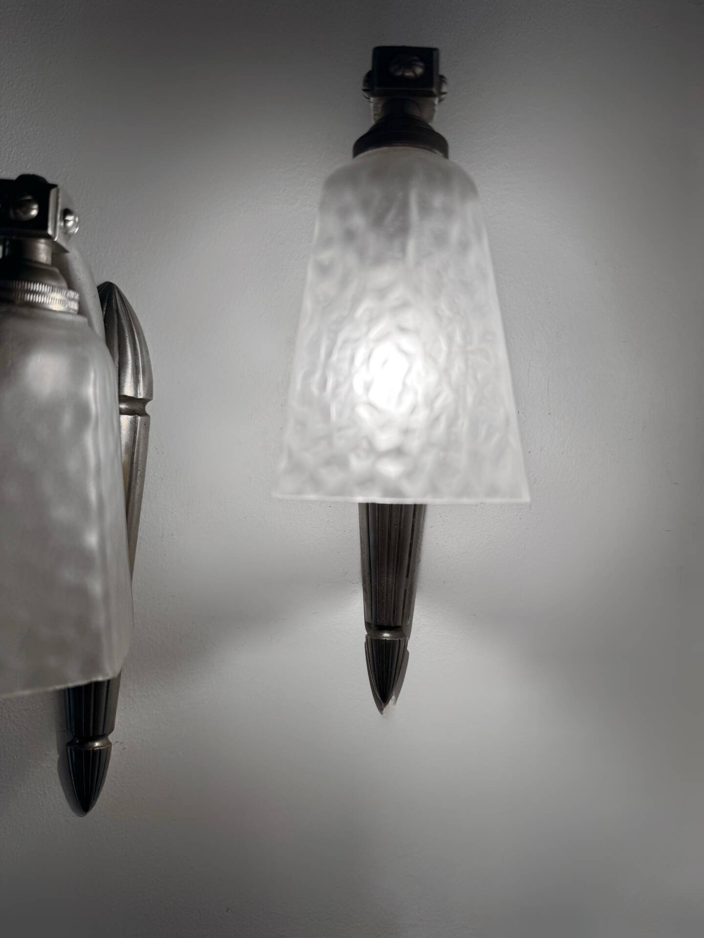 Silver Art Deco wall lights with frosted glass.