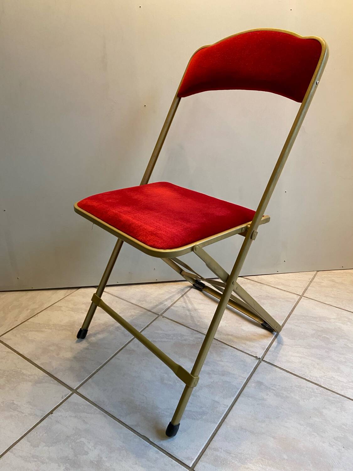 Velvet folding chair with gold metal.