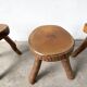 Set of three rustic solid wood tripod stools.