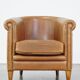 Fauteuil club en cuir de mouton de couleur cognac neutre et en bon état