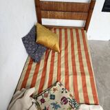 Brutalist style bed with chain and straw