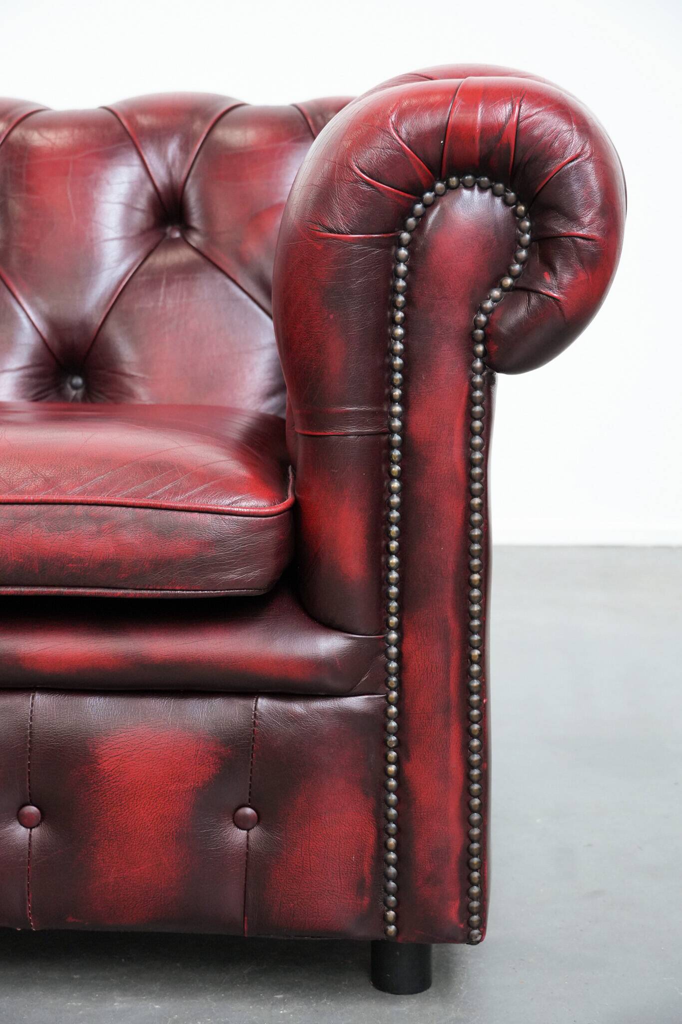 Red English cowhide Chesterfield armchair finished with decorative nails