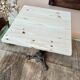 Bistro table with a raw wood top and a central cast iron base.