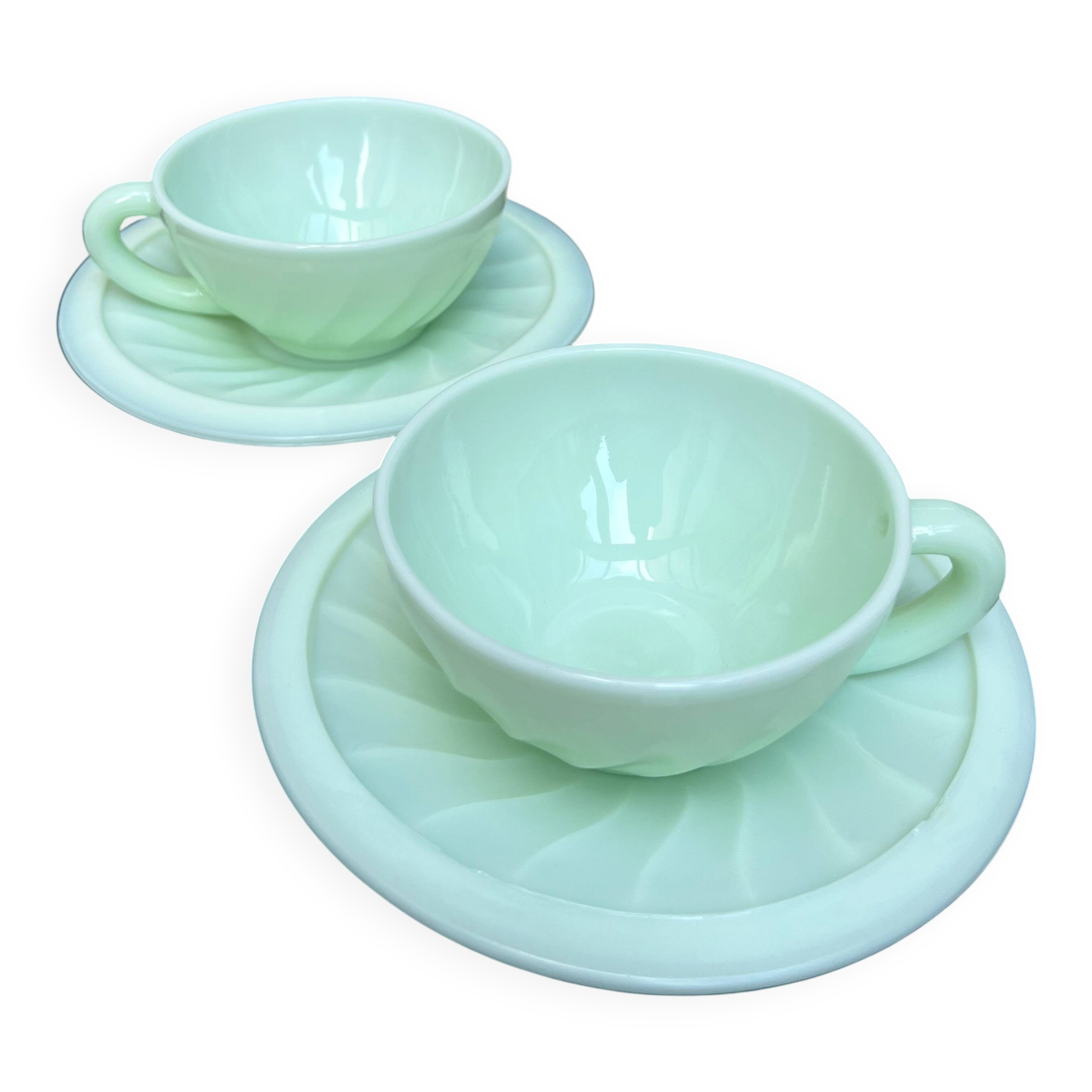 Two green opaline cup and saucer sets.
