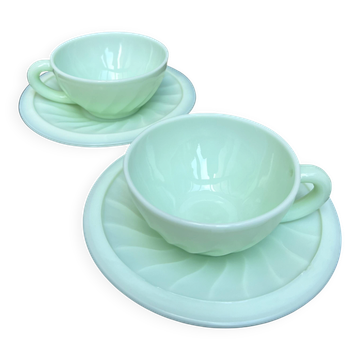 Two green opaline cup and saucer sets.