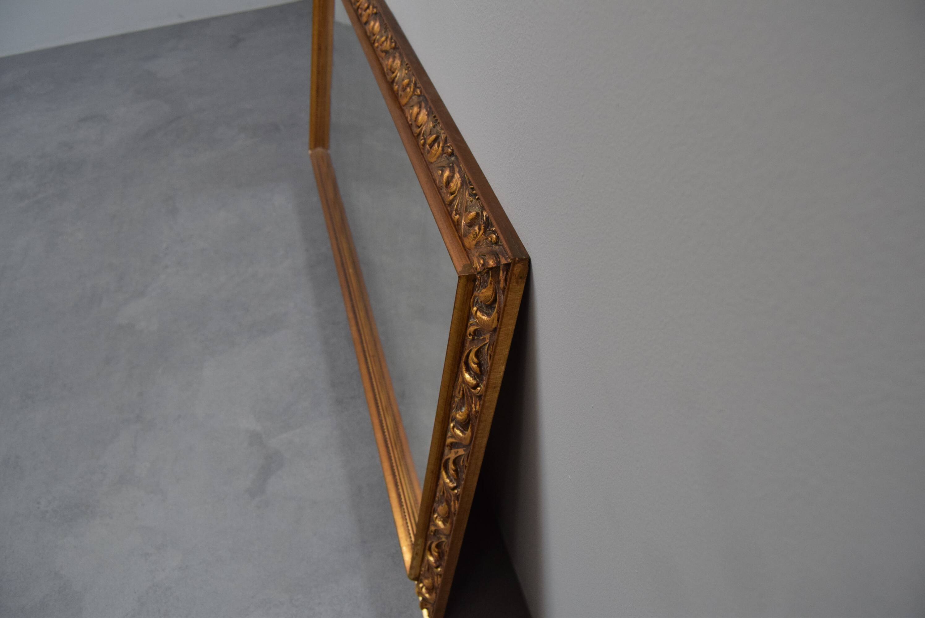 wall mirror in a decorative wooden frame.
