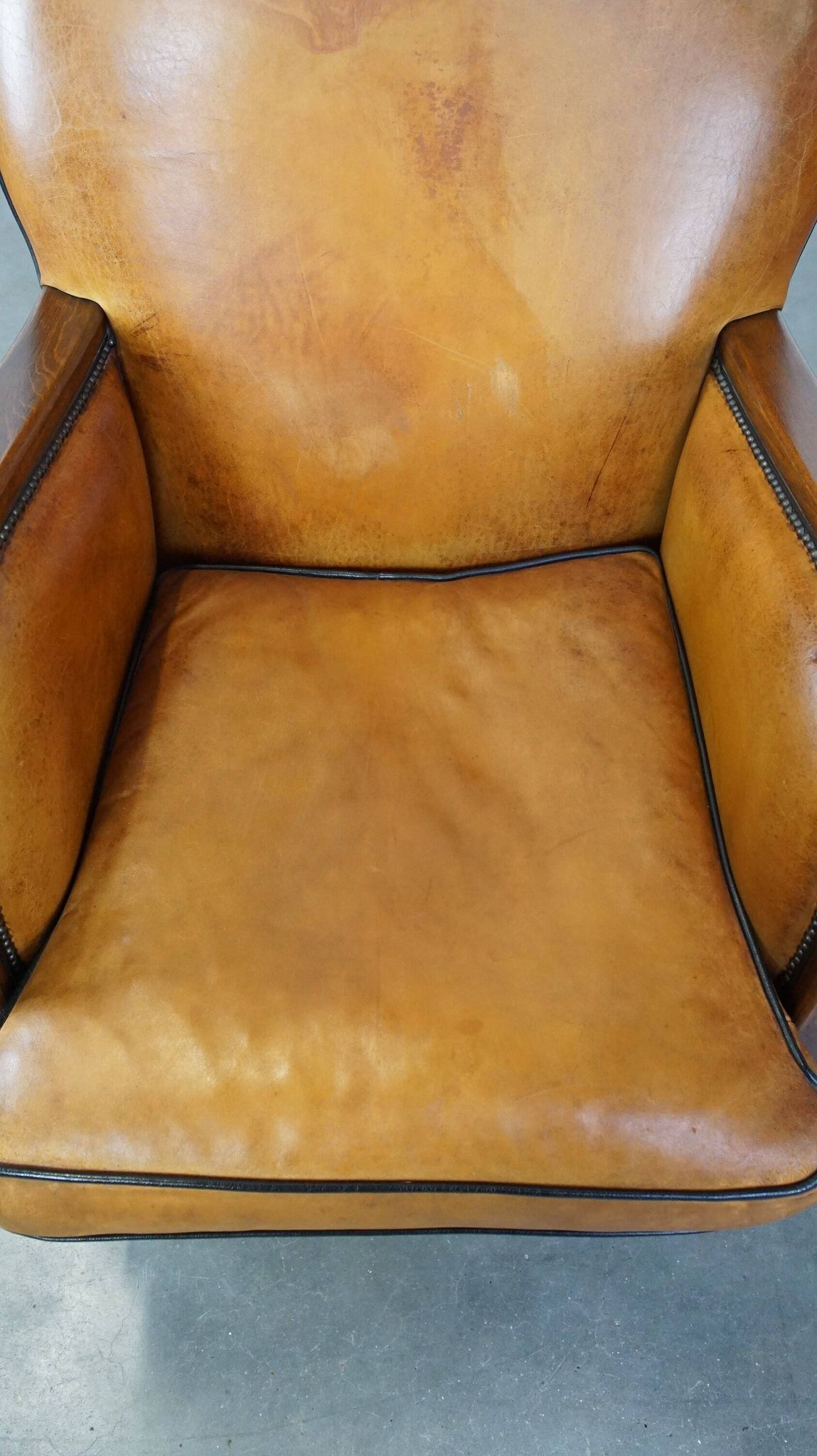 Unique, luxurious sheepskin armchair combined with wood and finished with decorative nails