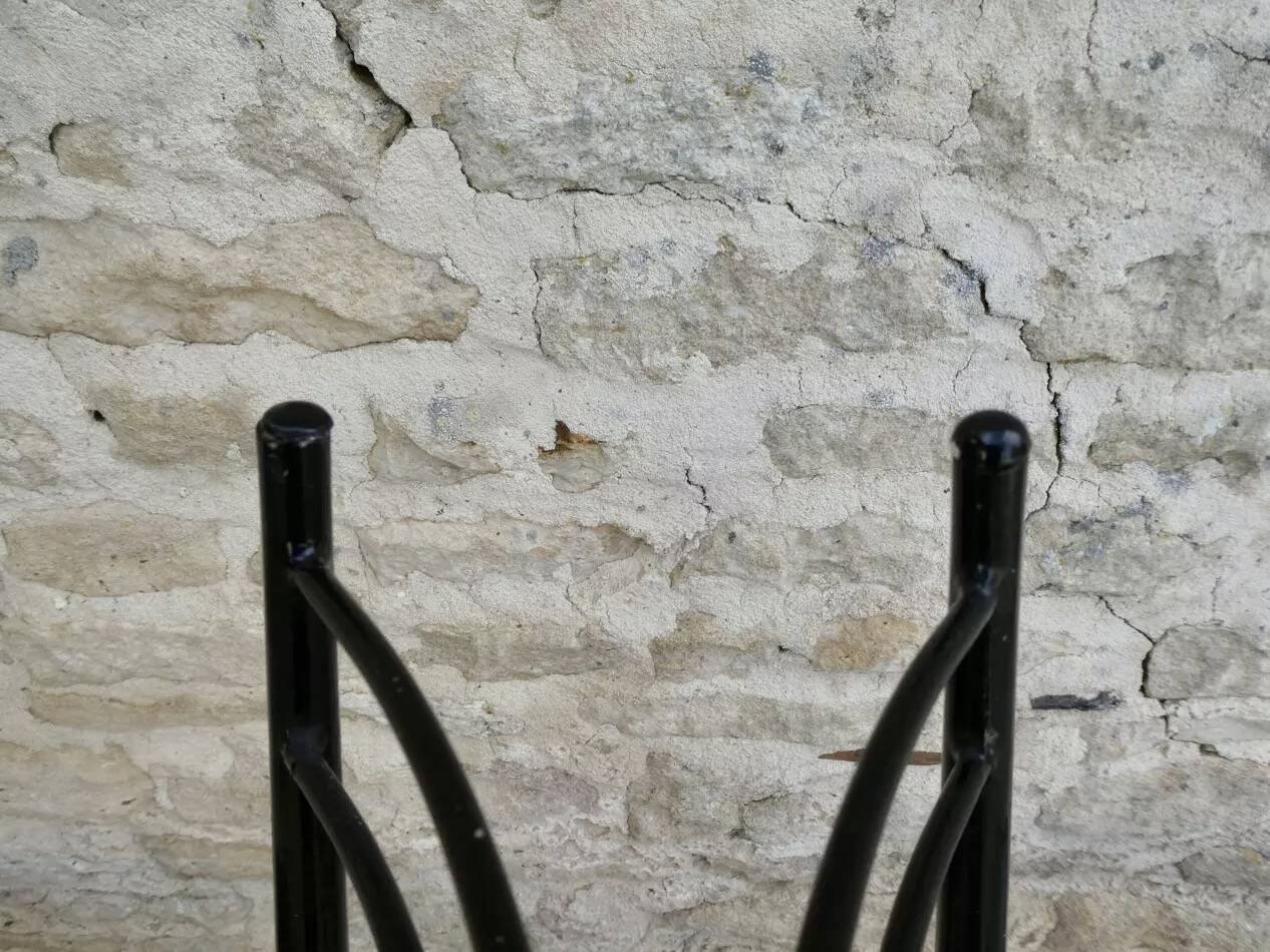 Black metal chairs with khaki faux leather seats, circa 1960.