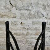 Black metal chairs with khaki faux leather seats, circa 1960.