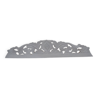 Decorative pediment in white carved wood