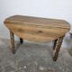 Antique wooden drop-leaf table with turned legs.