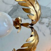 Pair of palm leaf wall lights in Hollywood Regency style with opaque globes by Hans Kögl, Germany, 1970s.