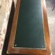 Walnut desk with green leather top resting on two trestles
