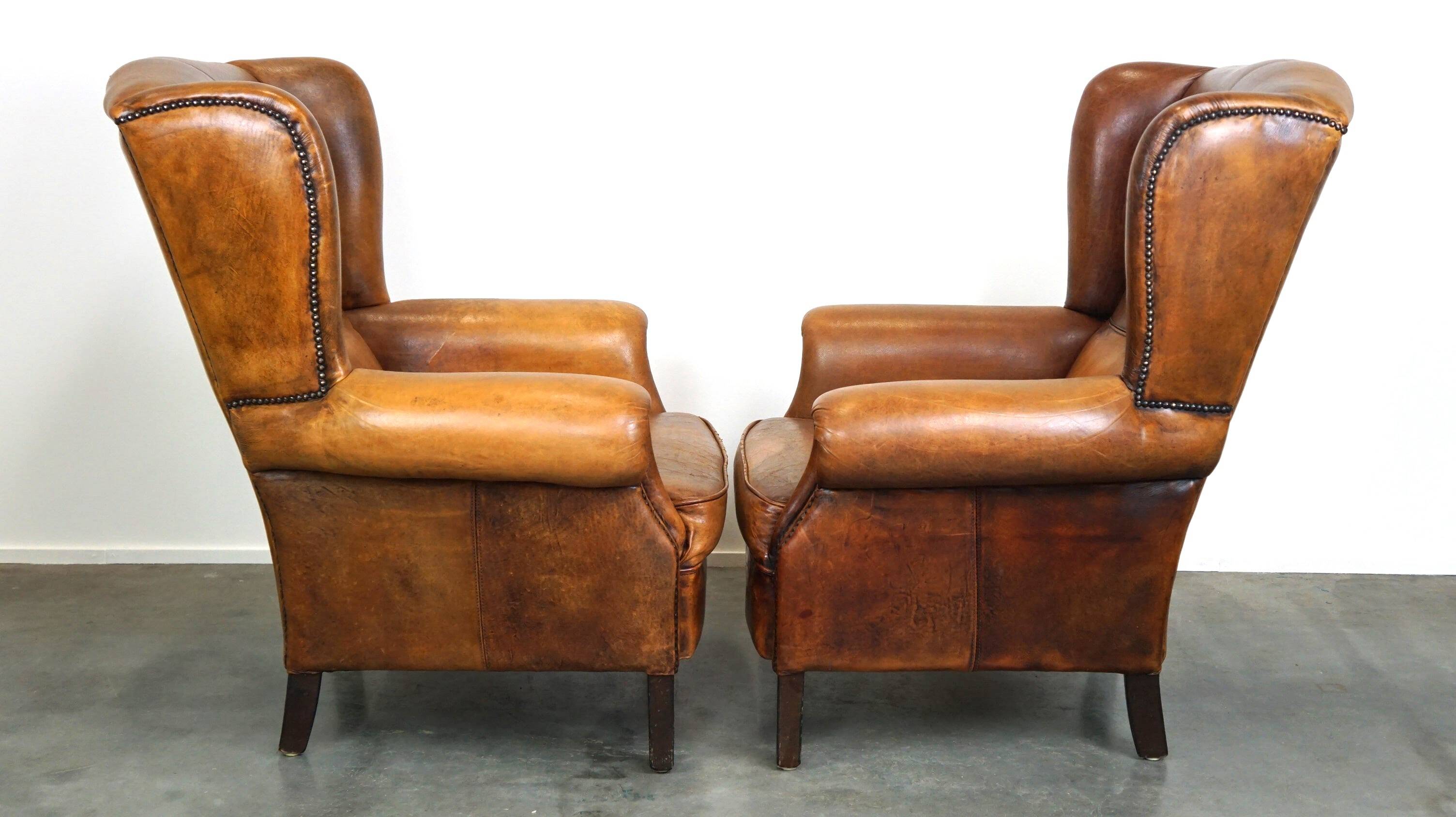 Set of 2 beautiful and correct sheep leather wingback armchairs with fixed seat cushions