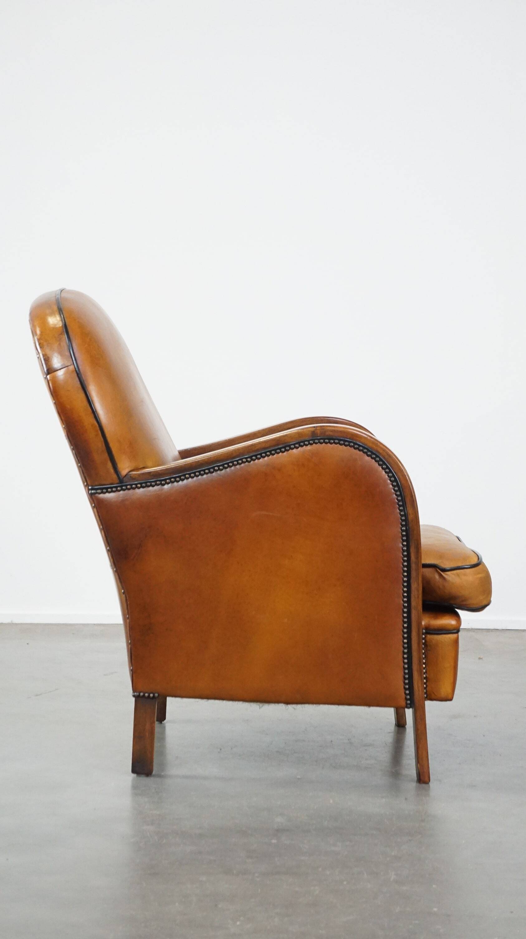 Unique, luxurious sheepskin armchair combined with wood and finished with decorative nails