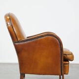 Unique, luxurious sheepskin armchair combined with wood and finished with decorative nails