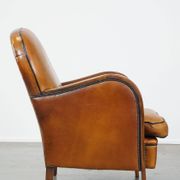 Unique, luxurious sheepskin armchair combined with wood and finished with decorative nails