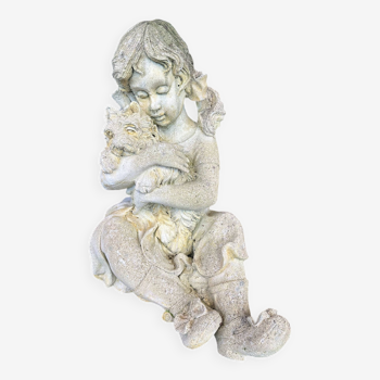 Stone garden statue of a child holding a dog