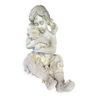 Stone garden statue of a child holding a dog