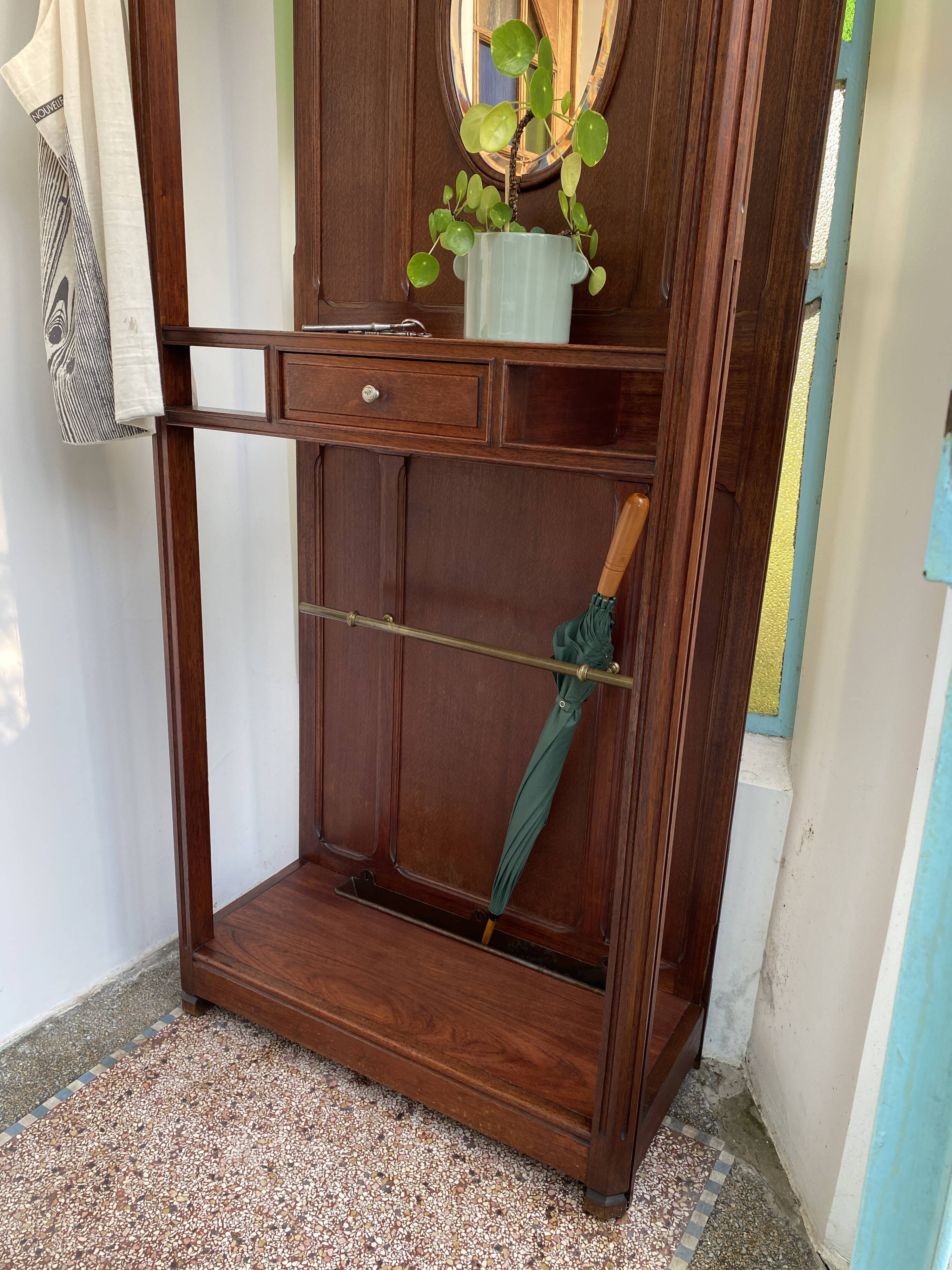 Antique wooden coat rack with mirror and shelf.
