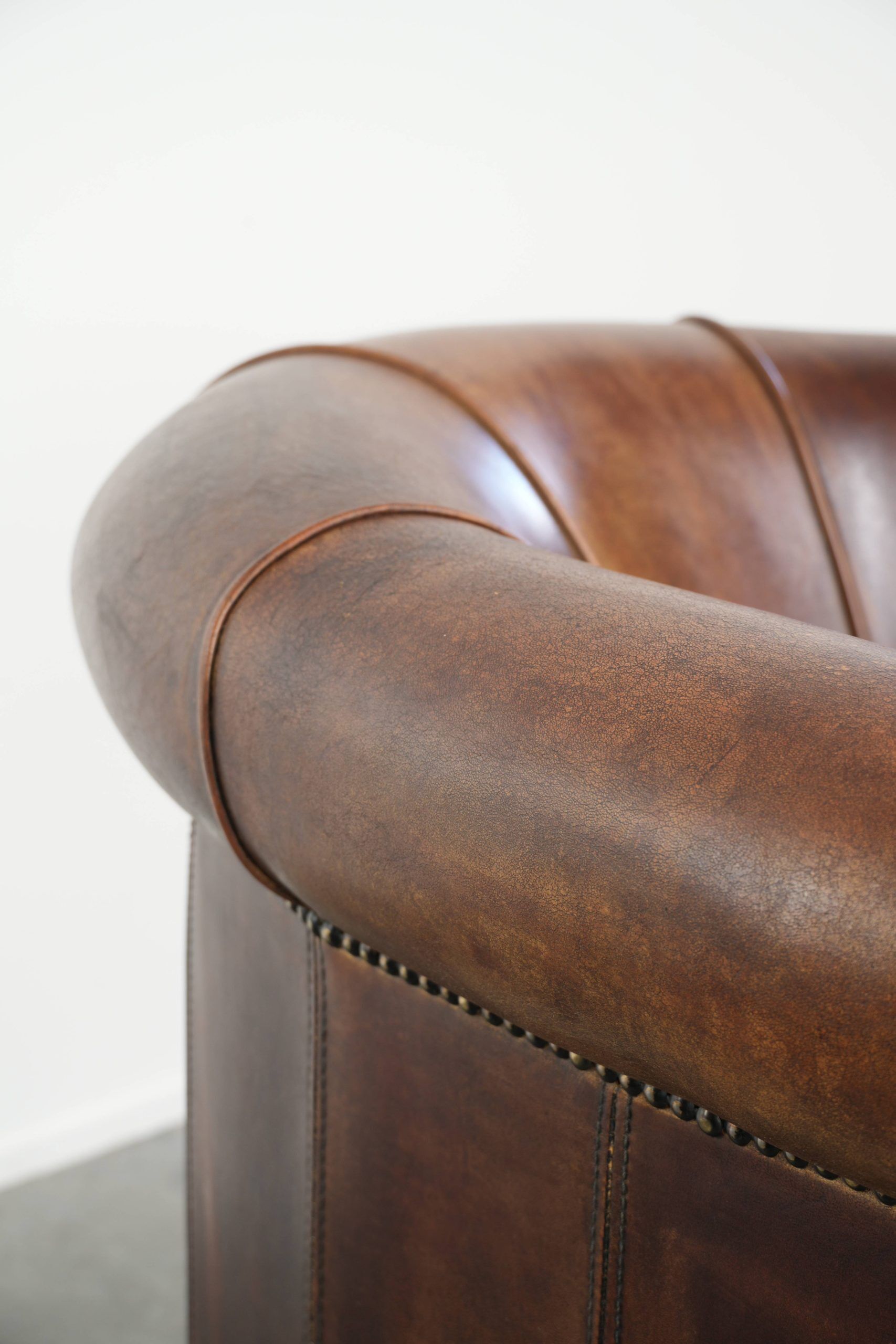 Sheepskin clubarmchair with beautiful patina finished with decorative nails