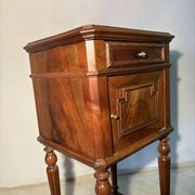 Antique wooden bedside table with turned legs.