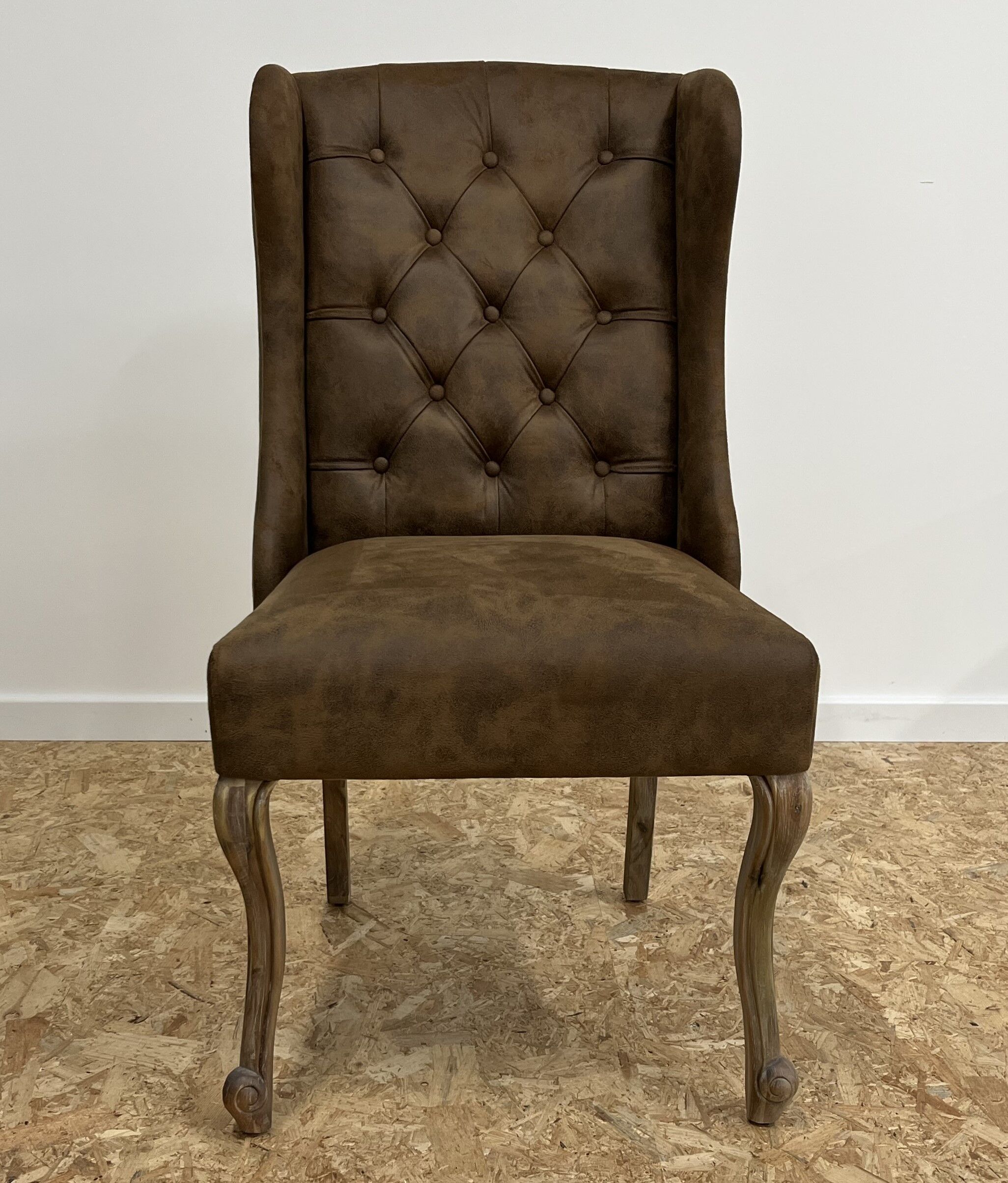 Upholstered armchair in brown imitation leather