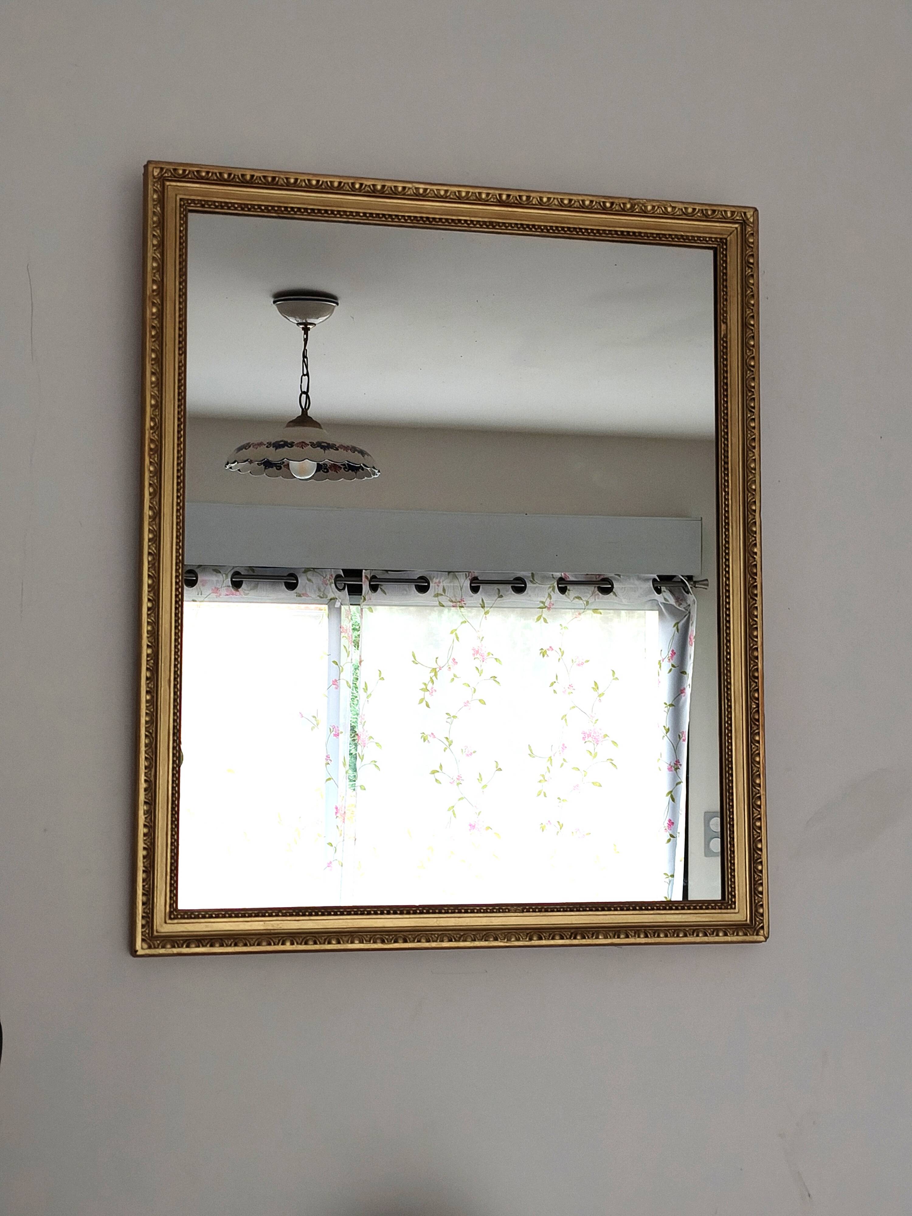 Antique mirror with a gilded frame and beaded border.