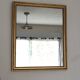 Antique mirror with a gilded frame and beaded border.