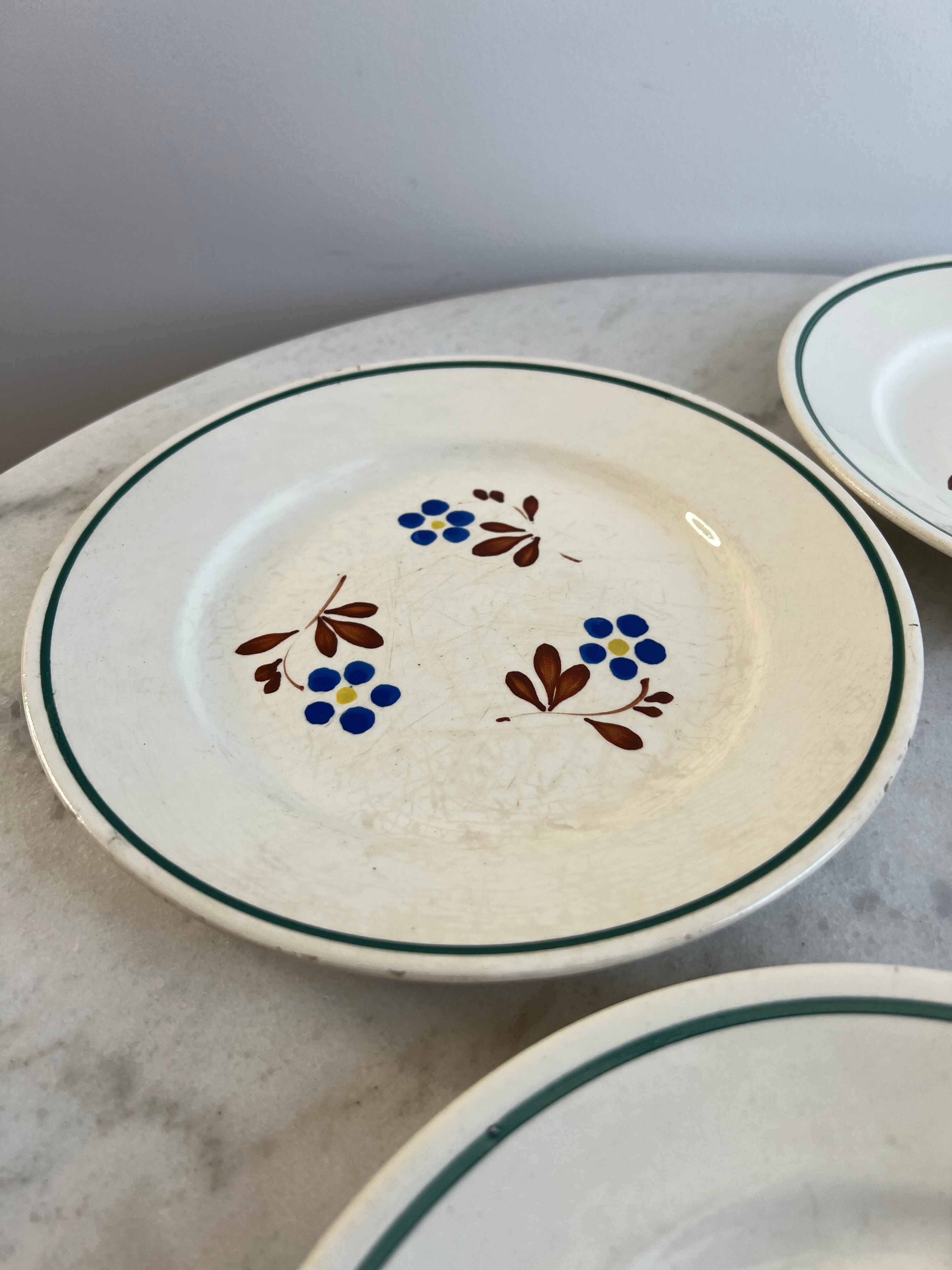 Set of 4 small flat plates with floral designs.