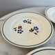 Set of 4 small flat plates with floral designs.